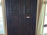 a tall wooden cabinet in the corner of a room