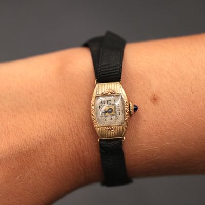 a woman ' s wrist that has a watch on it