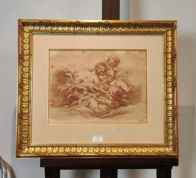 tableau représentant une femme tenant un enfant dans ses bras, posé sur un chevalet