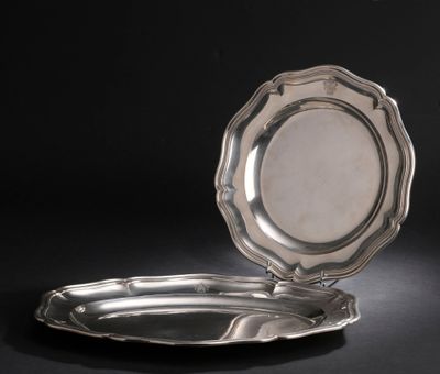 une assiette en argent posée sur une surface noire, avec un fond noir