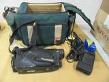 un sac vert contenant un appareil photo et d'autres objets, posé sur une table