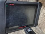 une tablette noire posée sur une table, avec une télécommande à côté