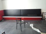 a black and white bench in a room with a red wall