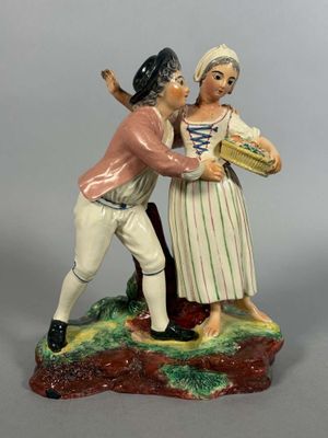 une figurine représentant un homme et une femme tenant un panier