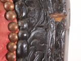 a close up of a red and black chair with beads on it