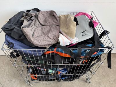 a shopping cart full of clothes and bags