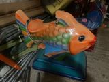 a colorful fish statue sitting on a blue stand
