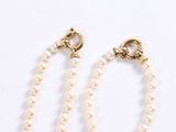 a close up of a pair of pearls on a chain