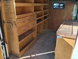 a van that has a bunch of wooden shelves in it