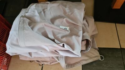 a pile of clothes sitting on the floor next to a red basket