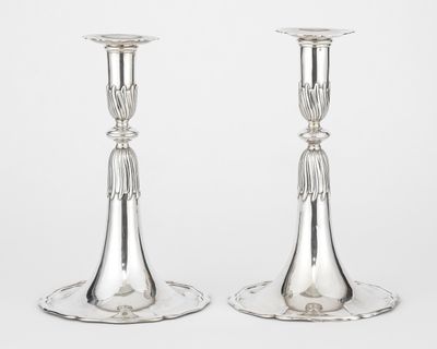 pair of silver plated candlesticks on a stand on a white background