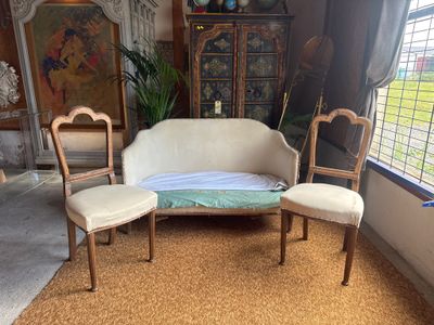 a couch and two chairs in a room with a window