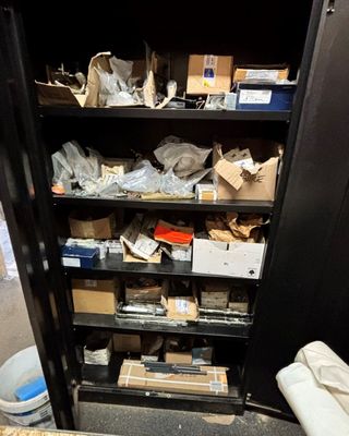 une armoire noire sur laquelle sont posées de nombreuses boîtes, dans une pièce