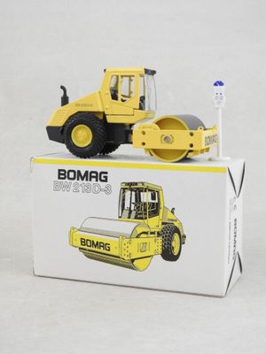 a small yellow construction vehicle sitting on top of a box