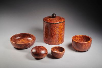 three wooden bowls and a wooden container on a gray surface