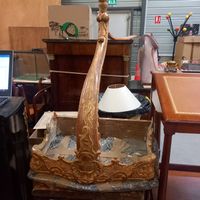 Une petite console en bois doré à décor de feuillages , blas…