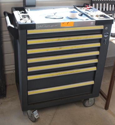 un chariot à outils noir et jaune sur lequel se trouve un ordinateur