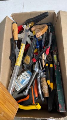 une boîte en carton remplie d'outils posée par terre