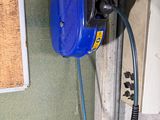 a blue water pump attached to a wall next to a window