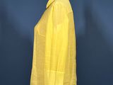 yellow shirt on a mannequin stand against a blue wall