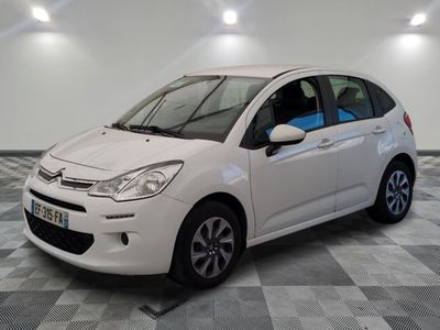 la petite voiture blanche est garée sur un sol en damier