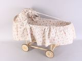 a small doll ' s pram with a floral cover on it