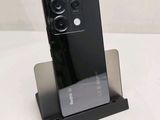 a black phone on a stand on a white surface