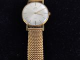 a close up of a gold watch on a black surface