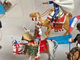 many figurines of people riding horses in a display case