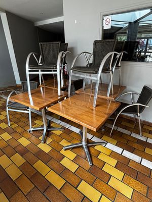 des tables et des chaises dans une pièce au sol carrelé et dotée d'une fenêtre