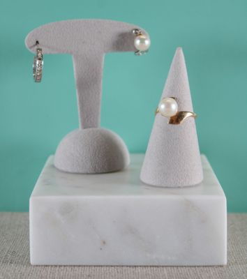 un gros plan sur une paire de boucles d'oreilles posées sur un socle en marbre
