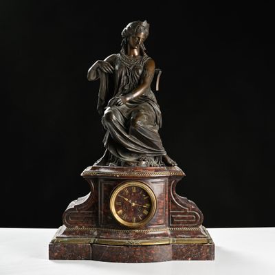 a statue of a woman sitting on top of a clock