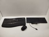 two keyboards and a mouse sitting on a desk