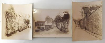 two old photos of a street and a building are hanging on a wall