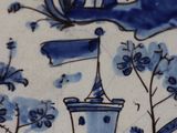 a blue and white plate with a castle on it