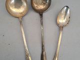 trois cuillères en argent et deux cuillères en argent posées sur une table