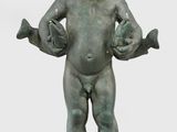 statue d'un enfant tenant un oiseau, posée sur un socle en marbre