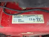 a close up of a red machine on the ground