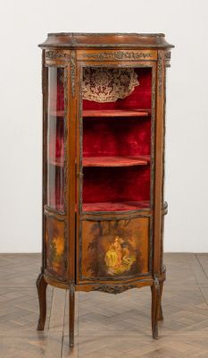 une vieille armoire en bois ornée de velours rouge et de décorations dorées