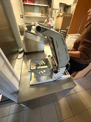 une femme debout dans une cuisine, à côté d'un appareil