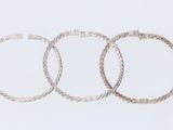 three silver rings on a white surface with a white background