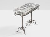 an iron table with a glass top on a white surface