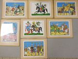 several framed pictures of cartoon characters on a wall in a room
