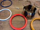 plusieurs bracelets et bagues différents sur une table en bois