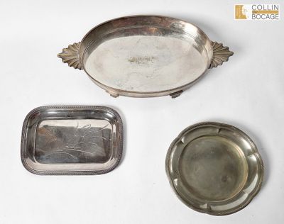trois plateaux en argent et une assiette en argent posés sur un plan de travail blanc