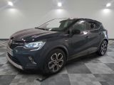 une voiture grise est garée dans une grande pièce au sol en damier