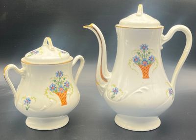 two white teapots with flowers on them on a table