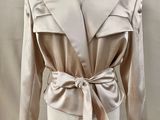 an image of a mannequin wearing a beige jacket with a bow tie