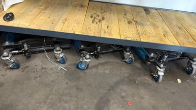 une table en bois munie de roulettes, dans un garage