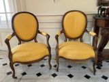 une paire de fauteuils rembourrés jaunes dans une pièce au sol à carreaux noirs et blancs
